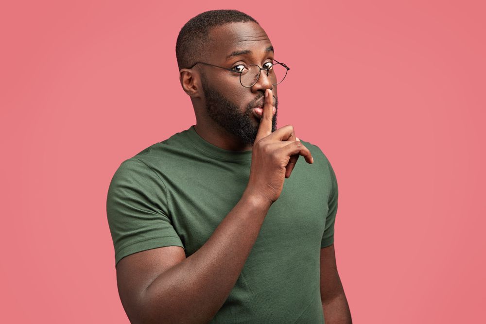 Man with finger over mouth